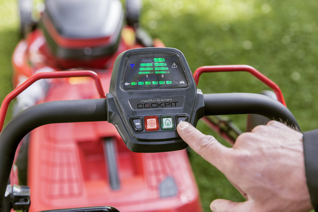 Панель керування смартфункціями на рукоятці косарки має кнопку безпечного запуску, індикатори заряду акумуляторів, індикатор підключення до додатка AL-KO inTOUCH та індикатор повідомлення про помилки.